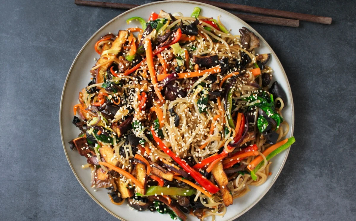 Vegan Japchae with glass noodles, vegetables, and smoked tofu