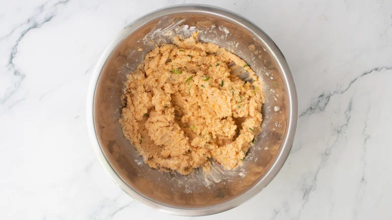 A fully loaded mashed potato in a large metal bowl