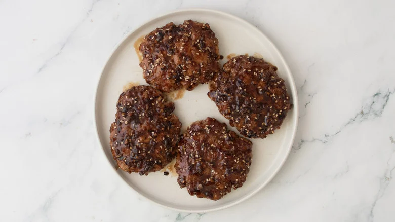 Grilled and glazed patties on a white plate