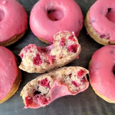 Pink glazed donuts with a bite taken